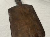 an old wooden cutting board on a white sheet