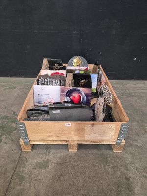 une caisse en bois remplie d'objets divers posée sur un sol en béton