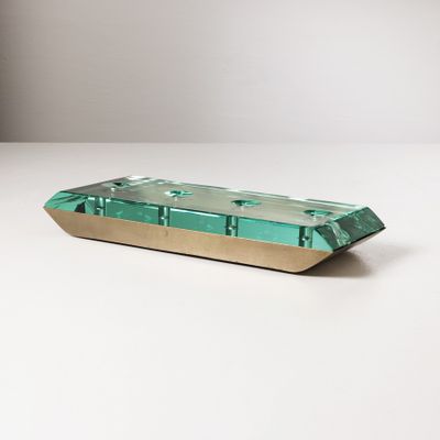 un gros plan sur un plateau vert et doré posé sur une table blanche