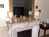 a living room with a fireplace and a mirror on the wall