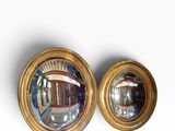 pair of round convex mirrors on a white surface