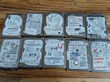 Plusieurs disques durs sont empilés les uns sur les autres sur une table en bois