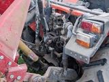 a tractor with a plow attached to it in the grass