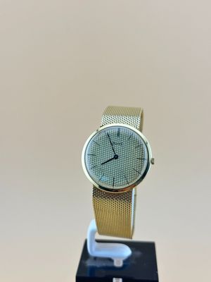 une image représentant une montre posée sur un socle, sur fond blanc