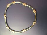 une photo d'un collier en fil métallique et en or