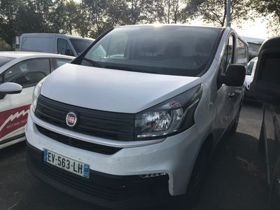 une camionnette blanche garée dans un parking avec d'autres voitures