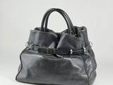 a black leather handbag with buckles and a strap