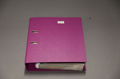 a pink binder with a piece of paper sticking out of it