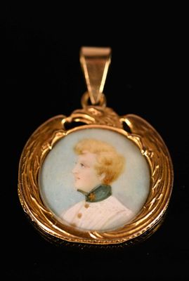 Un portrait ancien représentant une femme en robe blanche est représenté sur un pendentif plaqué or.