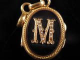 un gros plan d'un cadenas noir et doré sur lequel figure la lettre « m »