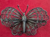 silver butterfly broocher on red cloth with red background