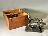 une petite boîte en bois contenant une machine à coudre