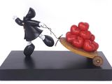 statue of a man pulling a wheelbarrow with tomatoes on it