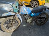 une moto tout-terrain garée à côté d'une voiture sur un parking