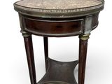 une table ronde avec un plateau en marbre et des pieds en bois