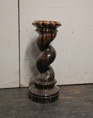 a black and brown candle that is on a table