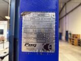 a sign on the side of a blue machine in a warehouse