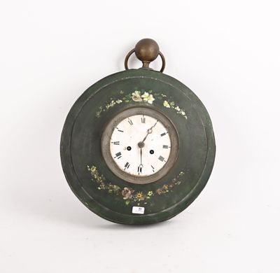 une image représentant une horloge verte accrochée à un mur blanc