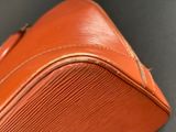 an orange piece of luggage sitting on a table