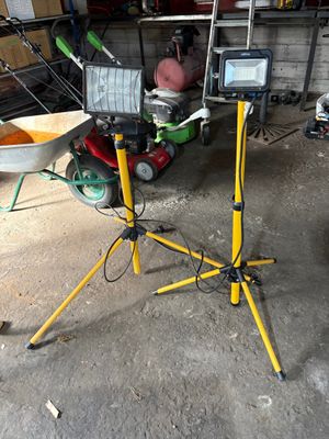 a man that is standing in a garage with a wheelbarrow