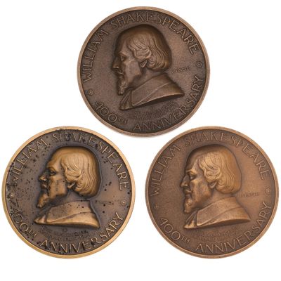 three bronze medallions depicting two men and a woman on a white background