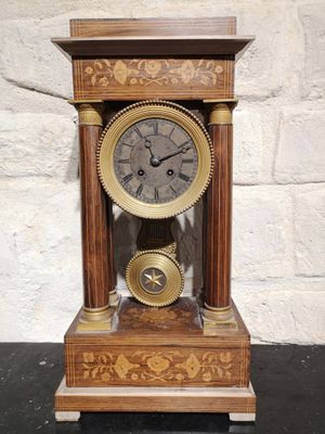 a clock that is sitting on a table in front of a brick wall
