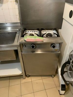 une petite cuisine équipée d'une cuisinière, d'un évier et d'un lave-vaisselle