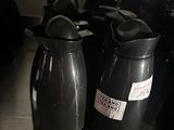 many black vases sitting on a table in a room