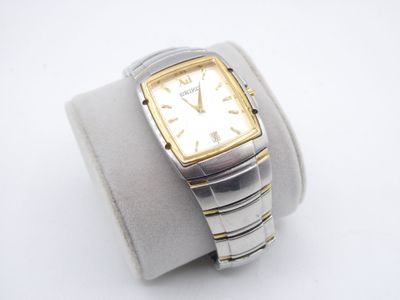 an image of a silver and gold watch on a white wrist
