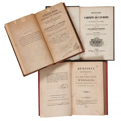 trois livres ouverts posés les uns sur les autres sur une table