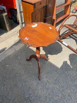 a small table with a wooden top and a rocking chair in front of it