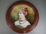 un tableau représentant une femme avec un chapeau rouge accroché au mur