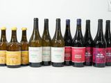 plusieurs bouteilles de vin sont alignées sur une surface blanche