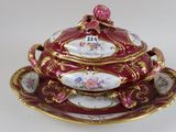 a red and gold plate with a bowl and saucer on it