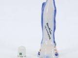 porcelain figurine of a woman with a crown on her head next to a thimble