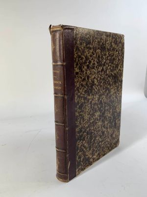 un vieux livre posé sur une table blanche à côté d'une tasse