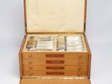 a wooden box with silverware in it on a white surface