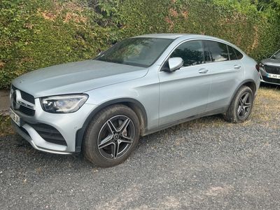 La Mercedes GLE est garée sur un parking, à côté d'une haie.