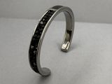 un gros plan d'un bracelet en argent orné de pierres noires