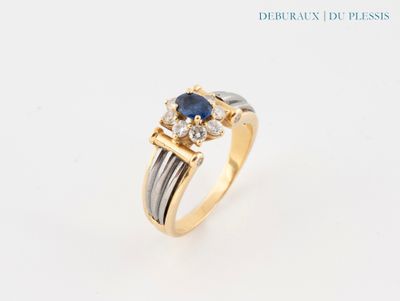 gros plan d'une bague en or avec un saphir et des diamants
