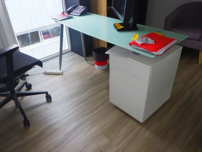 a desk with a computer and a chair in a room