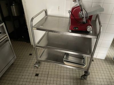 un chariot métallique sur lequel se trouve un mixeur rouge, dans une cuisine