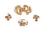 trois bagues en or et une bague ornée de pierres roses sur fond blanc