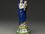 figurine d'une femme tenant un enfant dans ses bras