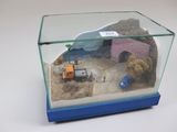 une petite maquette représentant un chantier, exposée dans une vitrine