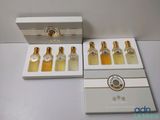quatre flacons de parfum dans une boîte blanche posée sur une table