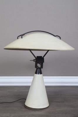 une photo d'une lampe de table blanche posée sur un parquet