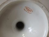 a close up of a white vase on a table