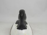 a black and white bird sitting on top of a white plate