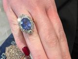 the woman is wearing a ring with a blue stone on it